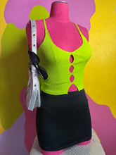 Load image into Gallery viewer, Mannequin wearing a green top and black skirt with sunglasses on a colorful background
